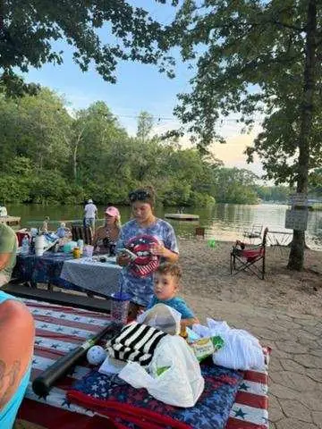A family at a picnic table at the water's edge